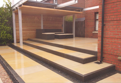 Sandstone paving with granite kerbs and firepit.